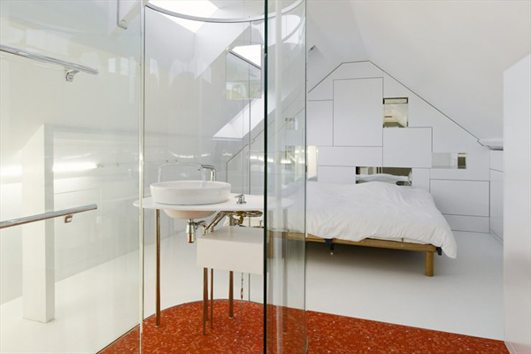 Habitación minimalista con baño de paredes de cristal